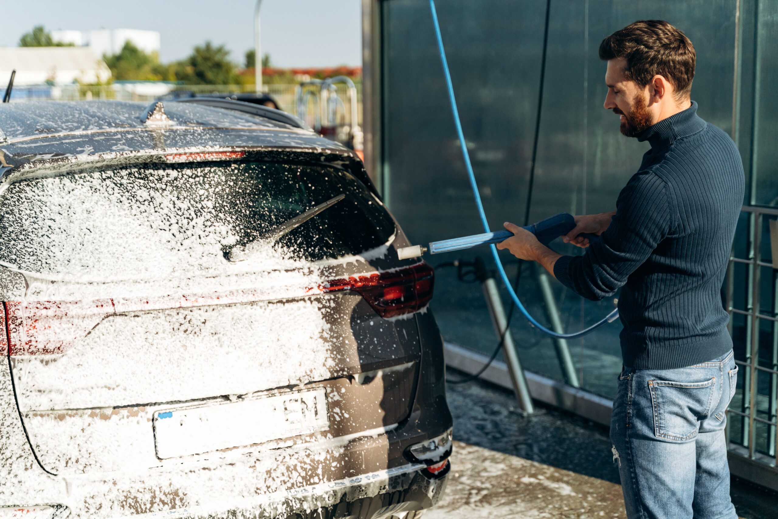Car owner washing her car at a self-serve car wash